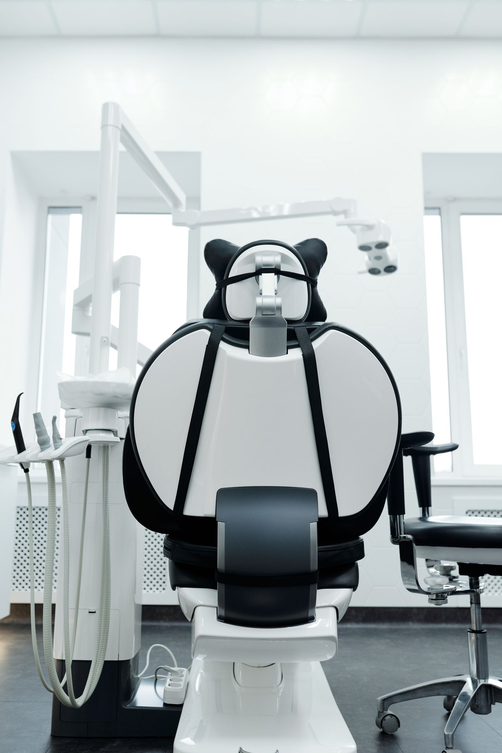 Modern dental operatory with chair, overhead light, and delivery unit ready for the next patient