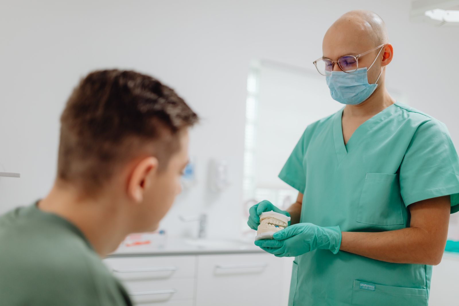 A dentist showing a dental model to a patient at chairside