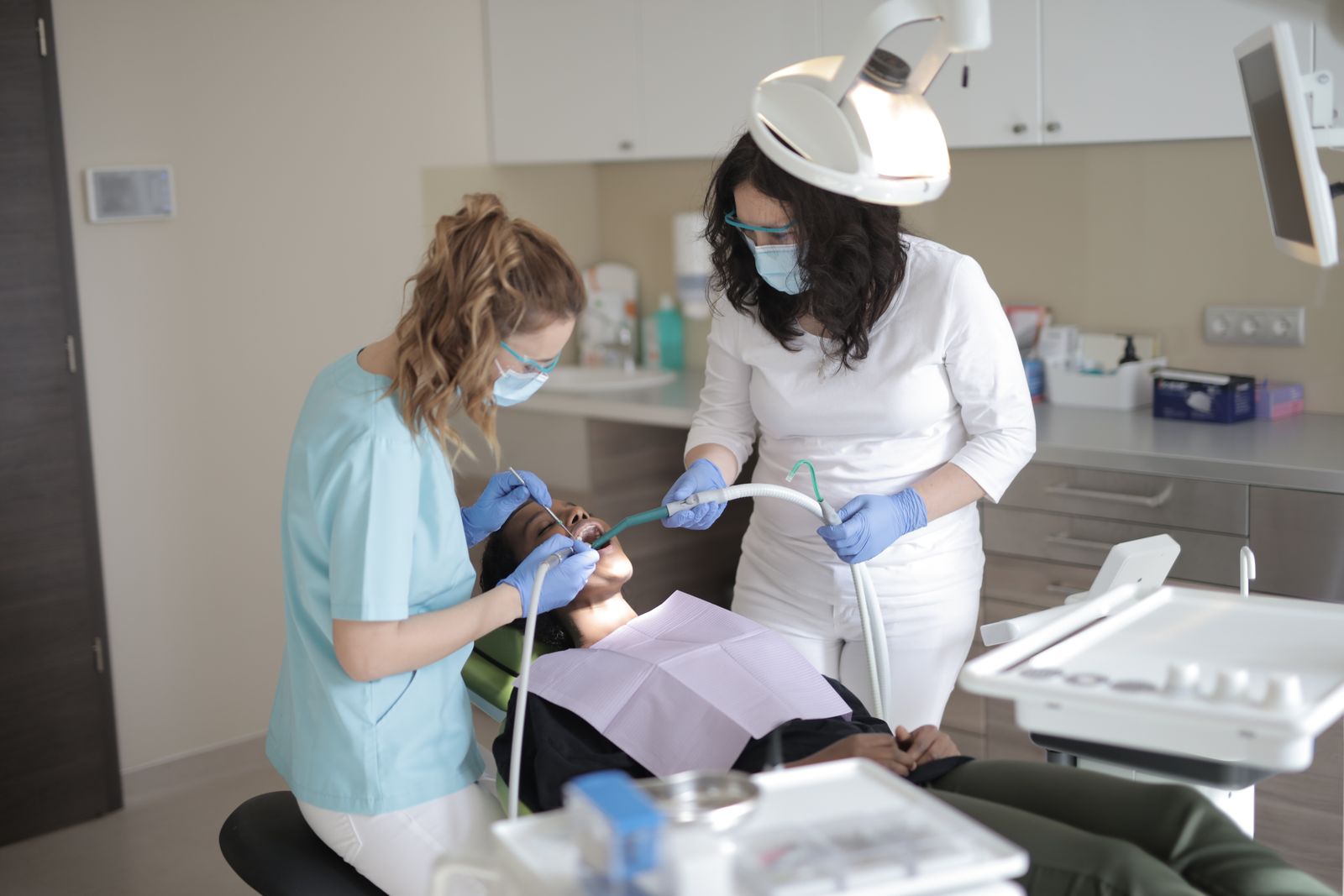 Dentist and assistant treating a patient in a modern dental operatory
